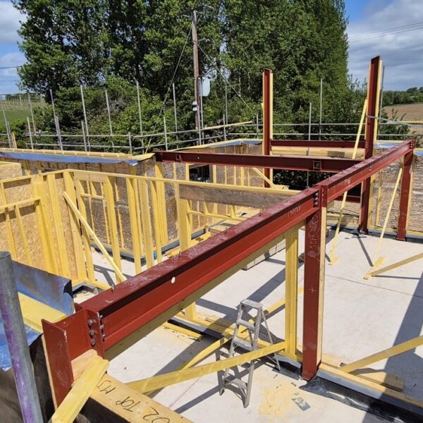Steel beam and timber frame Steel beam and timber frame integration during self-build home construction in Hampshire.