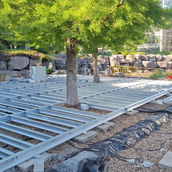 Galvanised steel beam grid installed around trees for decking support at Chiswick Business Park.