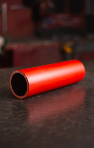 Red CHS steel beam displayed on a sleek black counter, showcasing its circular hollow section design. The bold red finish highlights its durability and strength, making it ideal for structural and construction applications. This CHS steel beam offers versatility and reliable performance for a wide range of projects.