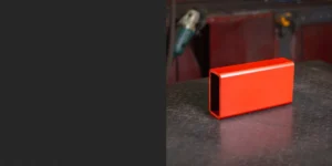 Red RHS steel placed on a black counter, showcasing its rectangular hollow section design. The bold red finish highlights its strength and durability, making it ideal for structural and construction purposes. This RHS steel offers versatility and reliability for a wide range of applications.
